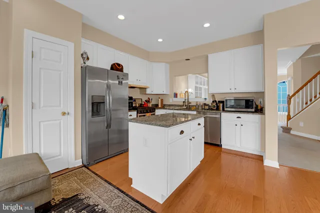 a kitchen with stainless steel appliances granite countertop a refrigerator a stove and a sink