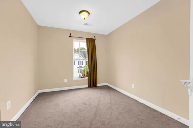 a view of a house with a large window and flower plants