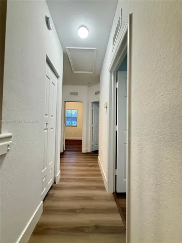 a view of a hallway with wooden floor and staircase