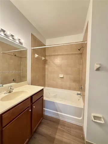 a bathroom with a shower sink vanity and mirror