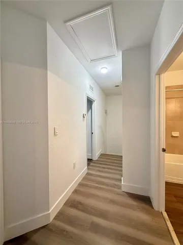 a view of a hallway with wooden floor