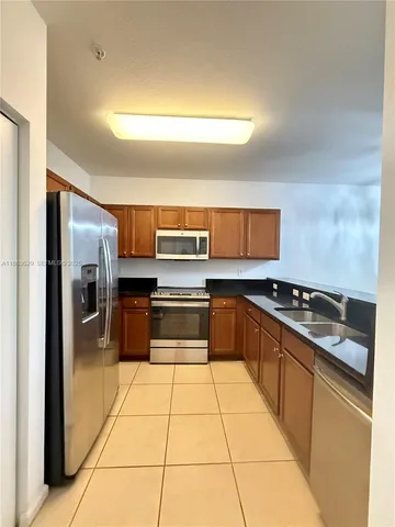 a kitchen with stainless steel appliances granite countertop a refrigerator and a stove