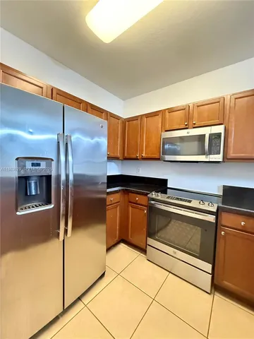 a kitchen with stainless steel appliances granite countertop a refrigerator and a stove top oven