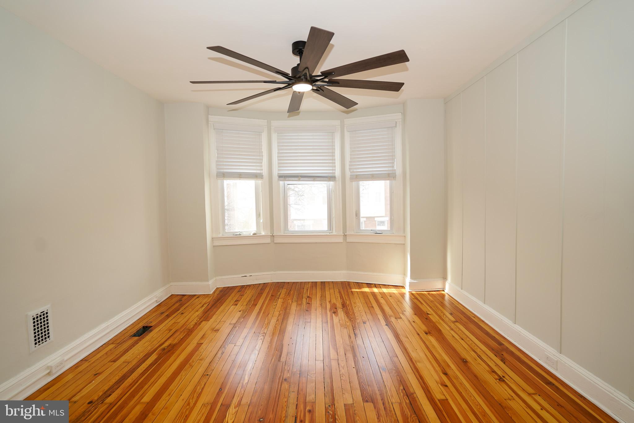 713 South Linwood Avenue Baltimore, MD 21224 - Photo 13 of 32 an empty room with wooden floor fan and windows