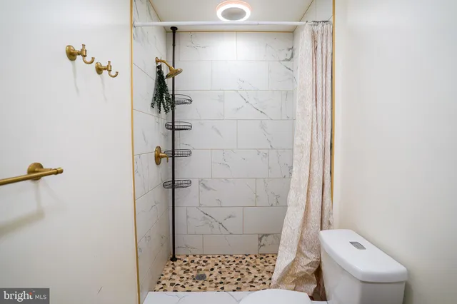 a bathroom with a toilet and a shower