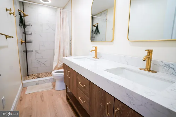 a spacious bathroom with a double vanity sink toilet and shower