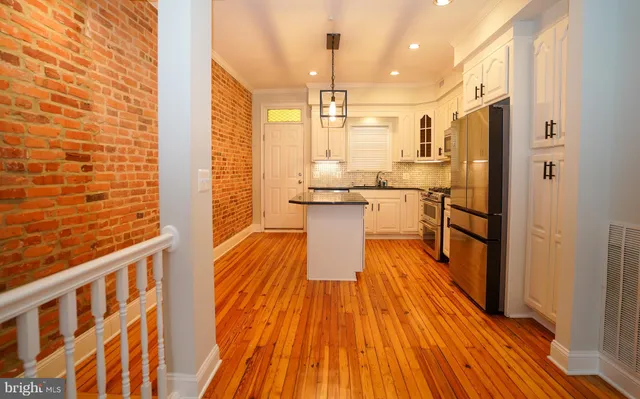 a kitchen with stainless steel appliances a refrigerator and wooden floor