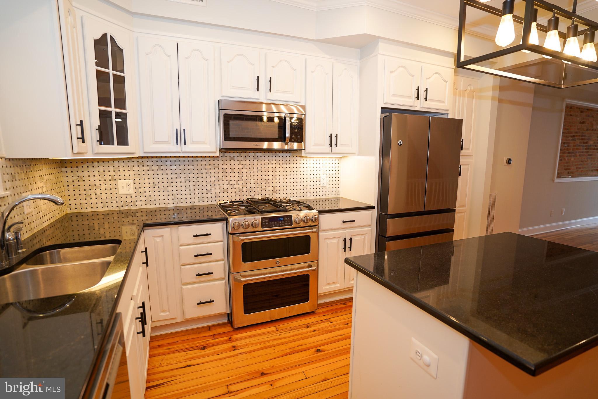 713 South Linwood Avenue Baltimore, MD 21224 - Photo 10 of 32 a kitchen with granite countertop a refrigerator sink and stove
