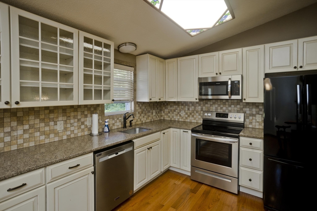 288 Fisk Road Hardwick, MA 01082 - Photo 14 of 42 a kitchen with granite countertop a sink a stove and cabinets