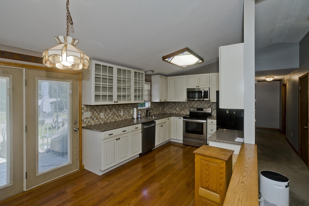 288 Fisk Road Hardwick, MA 01082 - Photo 17 of 42 a kitchen with stainless steel appliances kitchen island granite countertop a refrigerator and a stove top oven