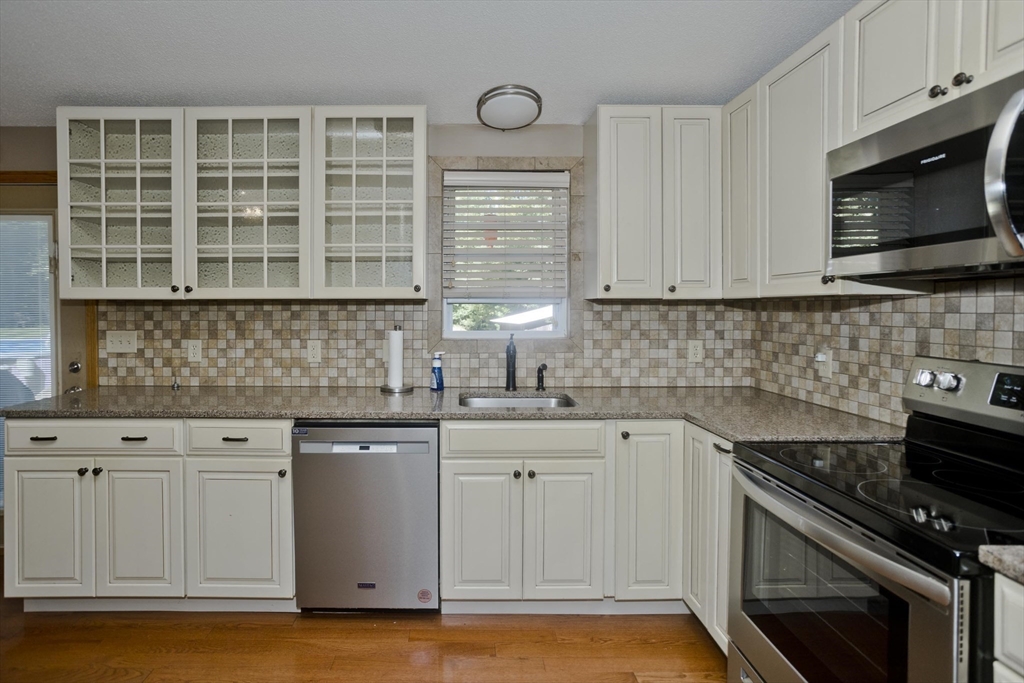 288 Fisk Road Hardwick, MA 01082 - Photo 18 of 42 a kitchen with stainless steel appliances granite countertop a sink a stove and a microwave