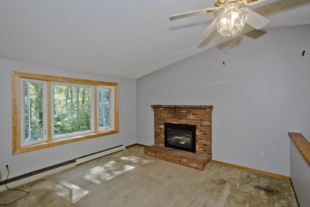 288 Fisk Road Hardwick, MA 01082 - Photo 23 of 42 a view of an empty room with a fireplace and a window