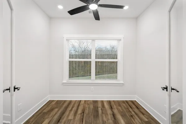 a view of an empty room with a window and closet
