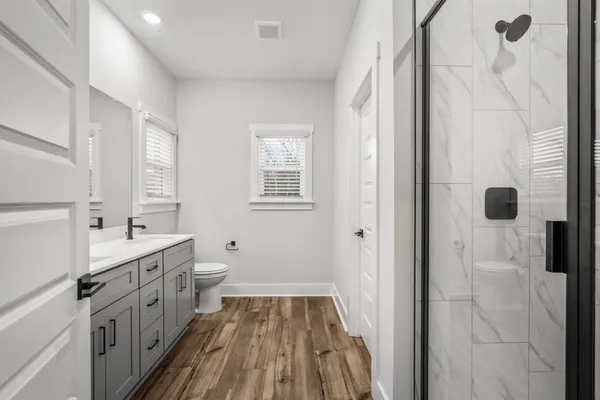 a bathroom with a double vanity sink toilet and shower