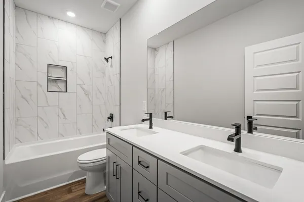 a bathroom with a sink a toilet and shower