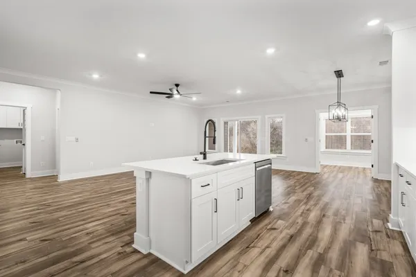 a kitchen with a sink and wooden floor