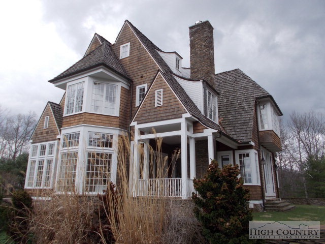 a front view of a house with a yard and potted plants