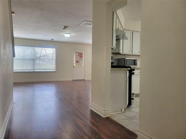 an empty room with wooden floor and a window