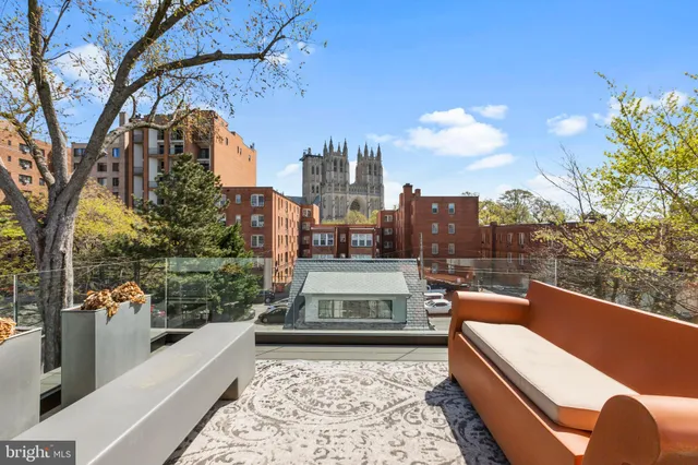 a view of a roof deck with couches and wooden floor