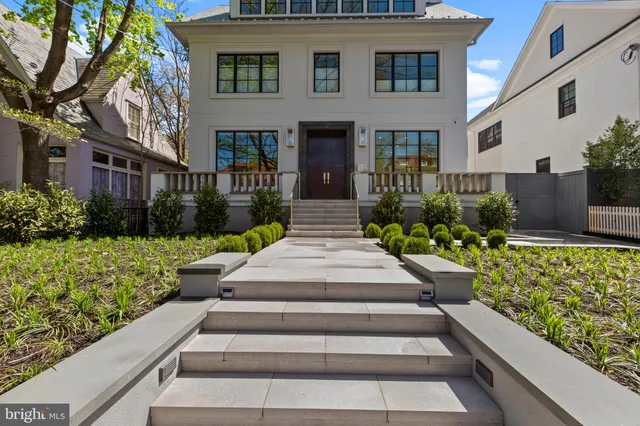 a front view of a house with a yard and potted plants