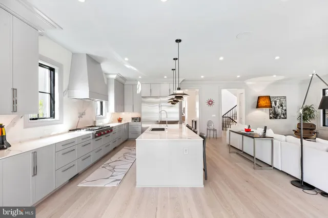 a large white kitchen with lots of counter space and stainless steel appliances