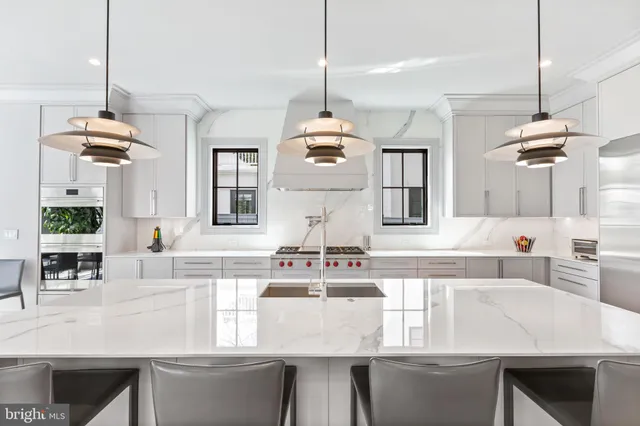 a kitchen with kitchen island granite countertop a stove a sink a dining table and chairs