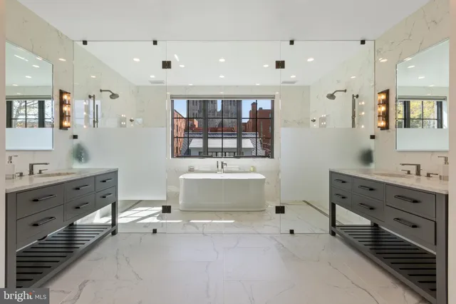 a bathroom with a tub sink double vanity and mirror