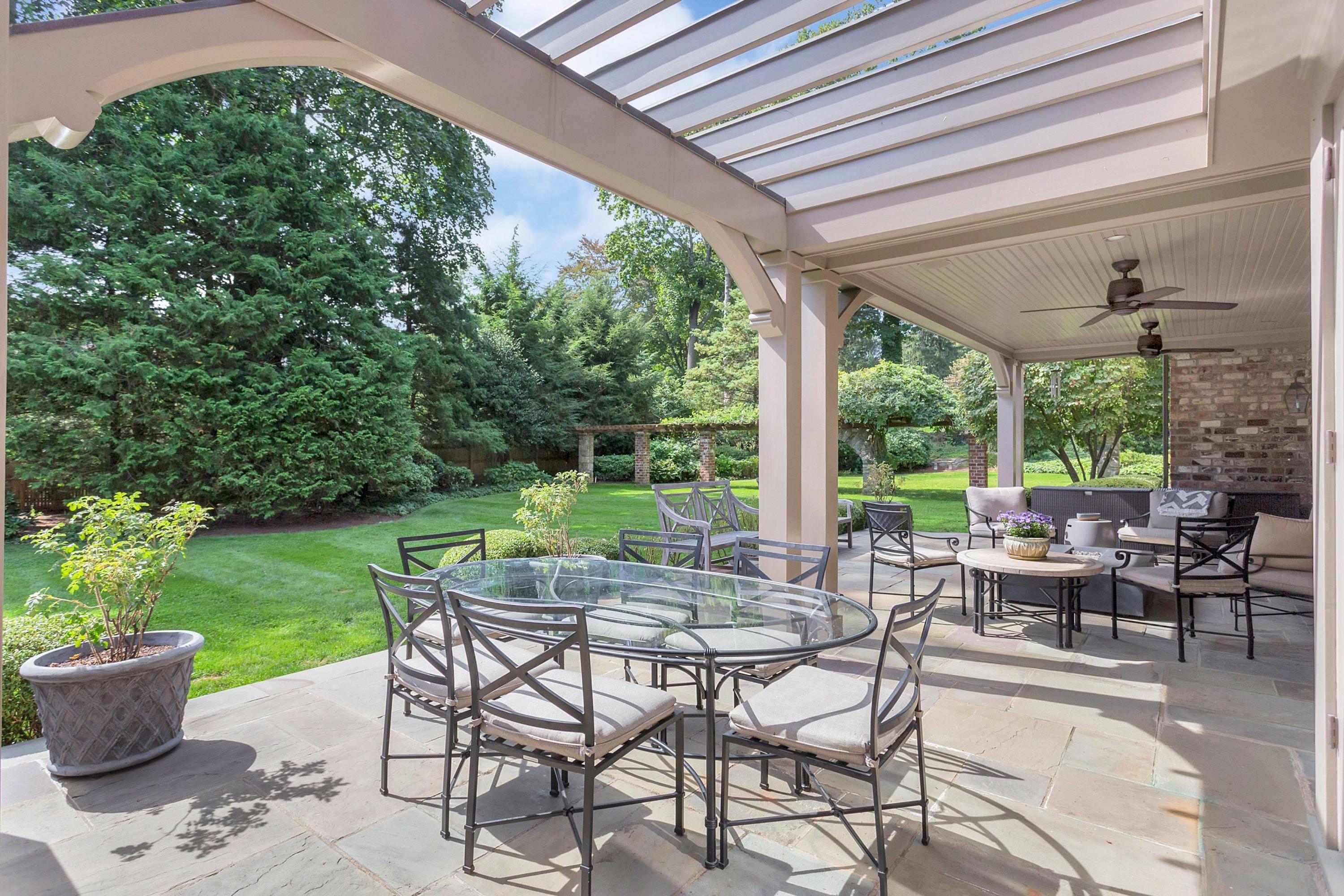30 Old Farm Road Darien, CT 06820 - Photo 36 of 42 a view of a patio with a dining table and chairs with plants and garden view