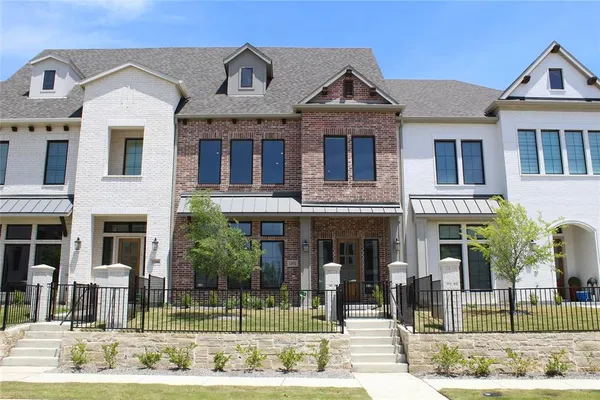 a front view of a residential apartment building with a yard