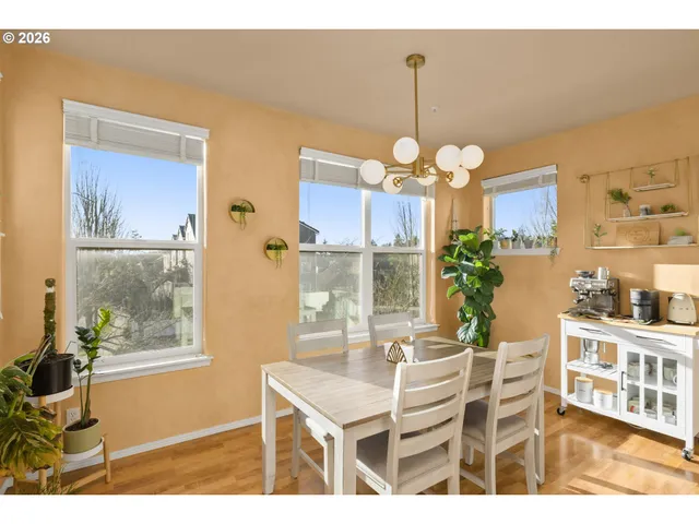 a dining room with wooden floor a chandelier a wooden table and chairs