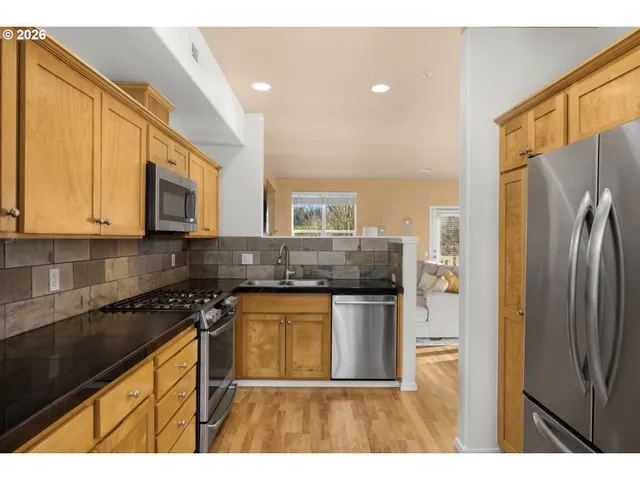 a kitchen with stainless steel appliances granite countertop a stove a sink and a microwave