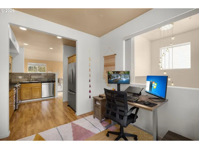 a living room with stainless steel appliances kitchen island granite countertop furniture and a wooden floor