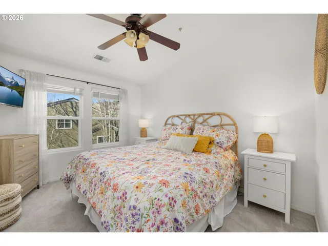 a bedroom with a bed a window and a chandelier