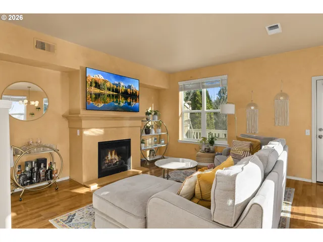 a living room with furniture a fireplace and a large window