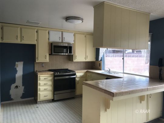 1219 North Erwin Street Ridgecrest, CA 93555 - Photo 4 of 20 a kitchen with a stove and a microwave