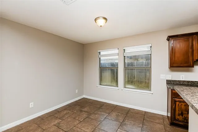 a view of an empty room with a fireplace and a window