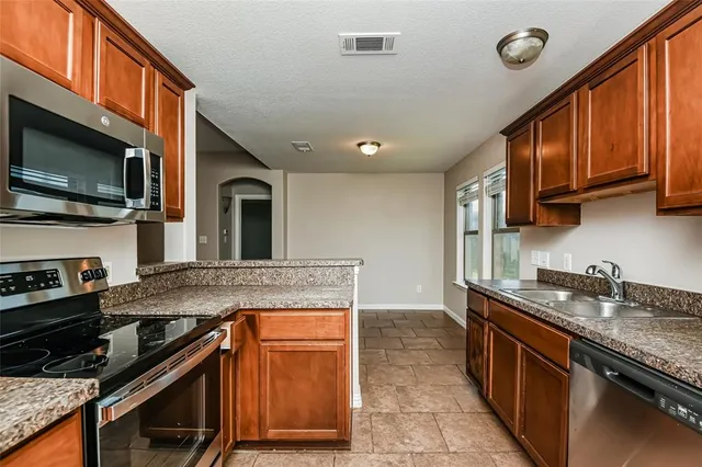 a kitchen with stainless steel appliances granite countertop a stove and a sink