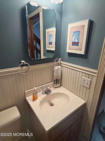 a bathroom with a sink mirror and toilet