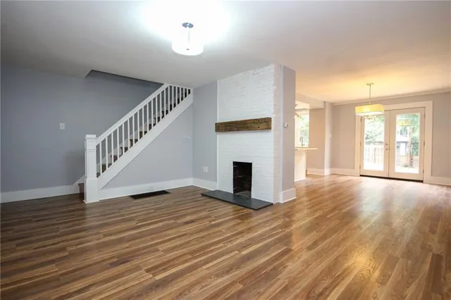 a view of empty room with wooden floor and fireplace