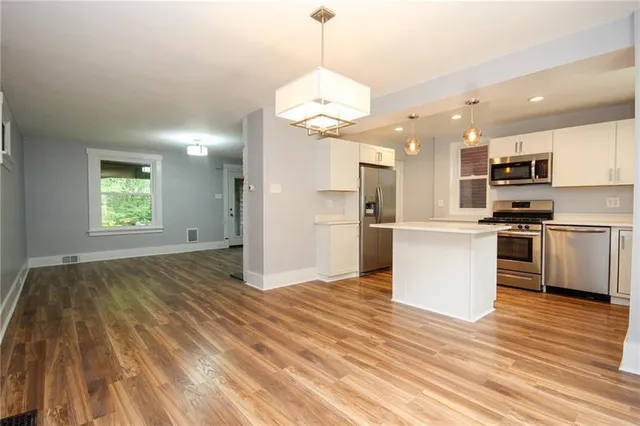 a view of kitchen with granite countertop cabinets and refrigerator
