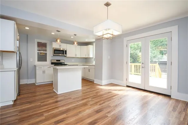 a view of kitchen with granite countertop stainless steel appliances cabinets and a wooden floor