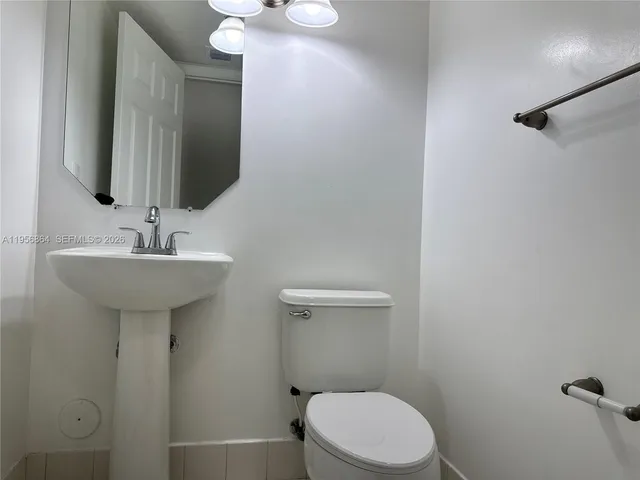 a bathroom with a sink toilet and a mirror