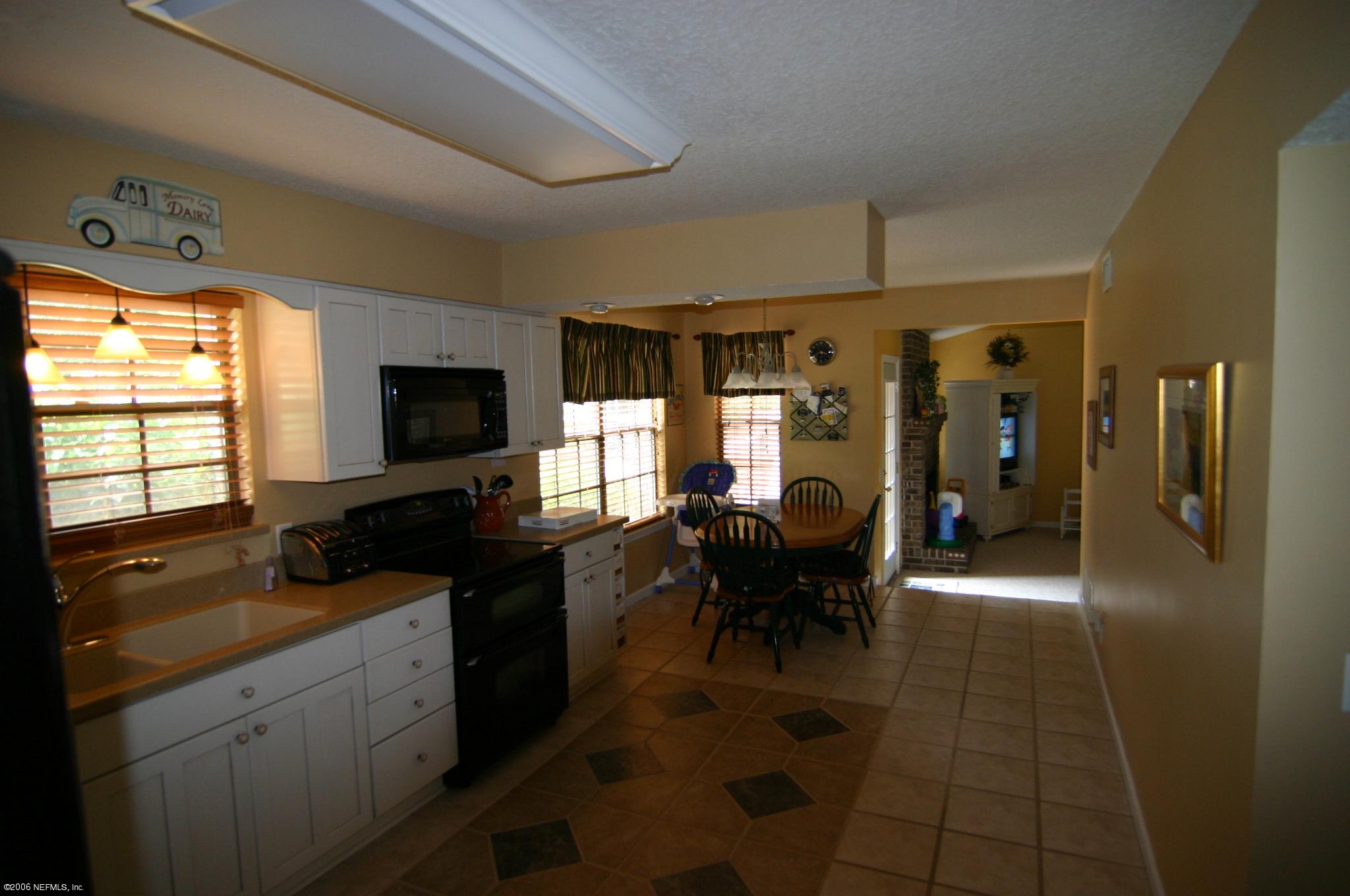 11743 Fort Caroline Road Jacksonville, FL 32225 - Photo 4 of 9 a living room with furniture and a flat screen tv