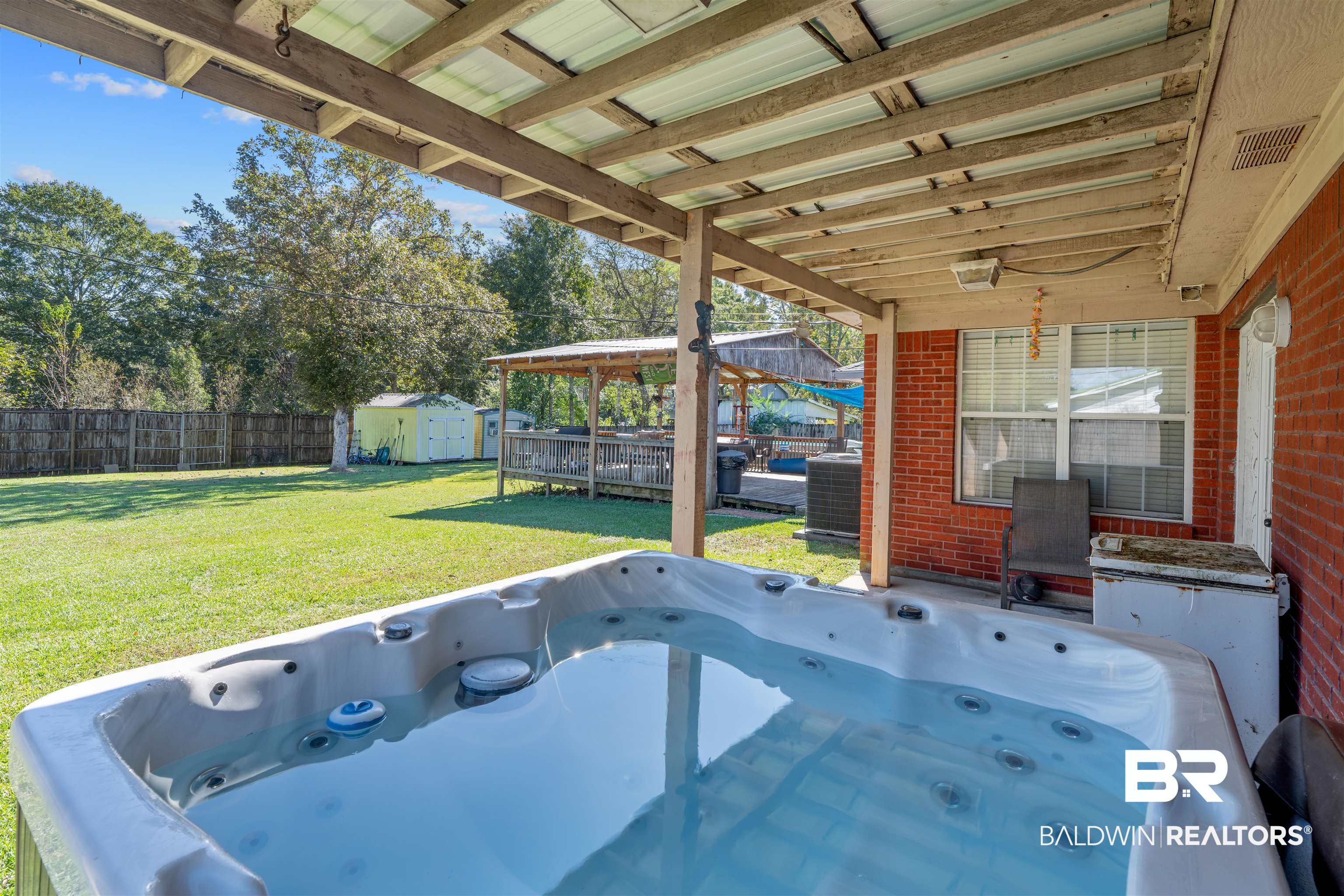 23186 Pecan Street Robertsdale, AL 36567 - Photo 22 of 36 Fenced backyard with a hot tub, a storage unit, and a patio