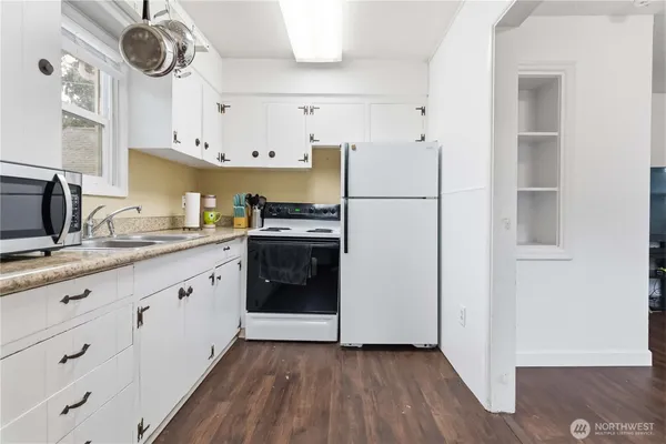 a kitchen with stainless steel appliances a refrigerator stove and white cabinets