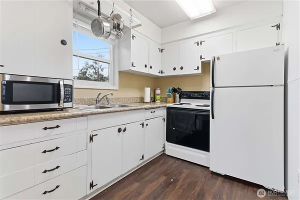 a kitchen with stainless steel appliances a microwave a stove and white cabinets