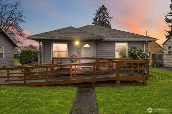 a view of a house with a wooden deck and a yard