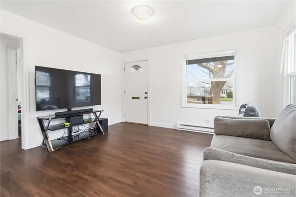 a living room with furniture and a wooden floor