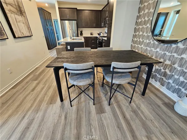 a kitchen with stainless steel appliances granite countertop a refrigerator a stove a sink and a microwave oven with wooden floor