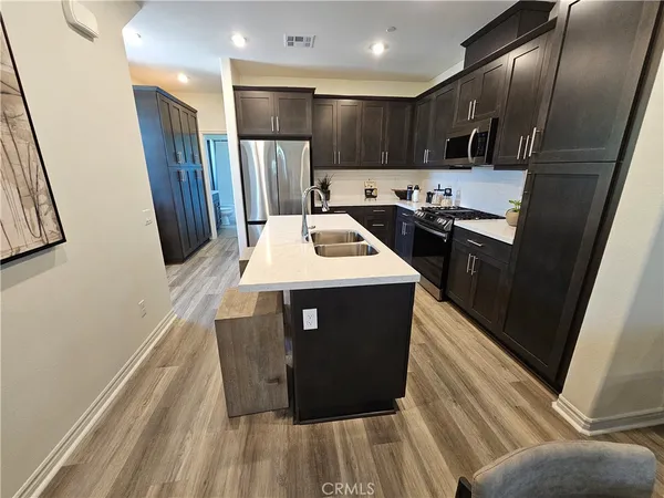 a kitchen with stainless steel appliances kitchen island granite countertop a refrigerator and a stove